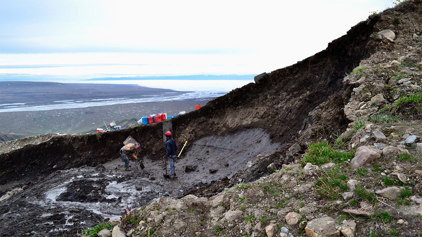 Researchers are shown by standing on a piece of ice of exposed glaciers, amid a landing of the Earth.